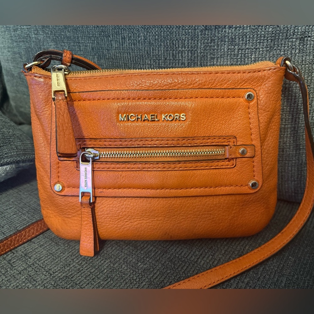 Michael Kors Tangerine Crossbody Bag used has stains inside and out. No holes.